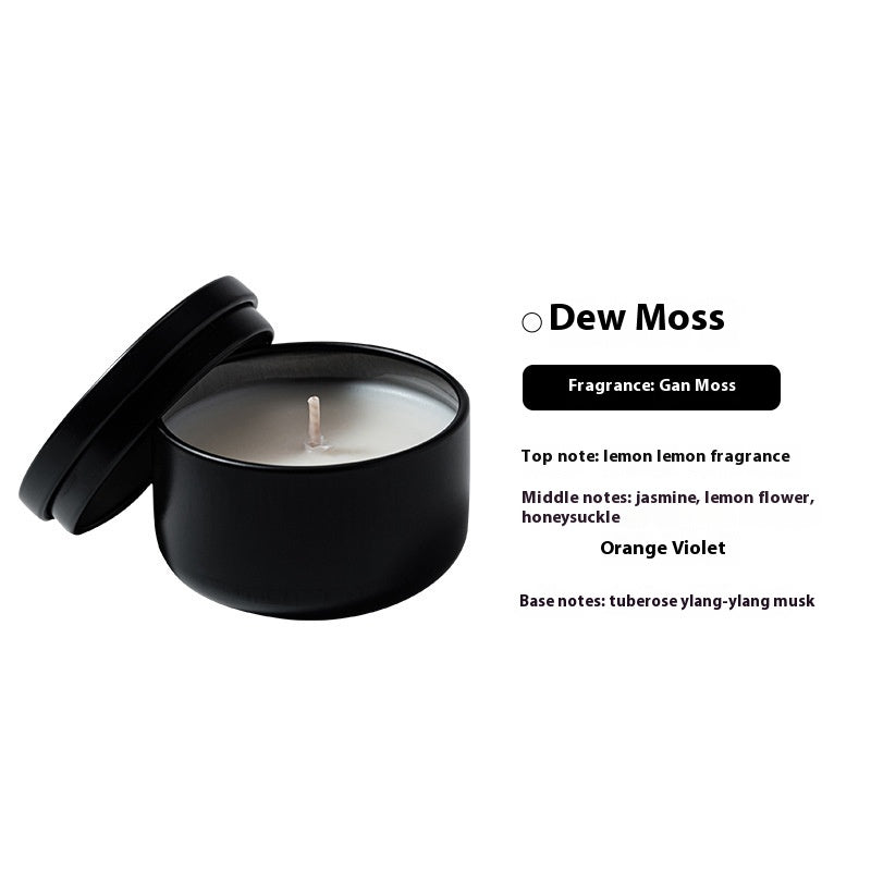 Black candle with lid on a white background, featuring fragrance information.
